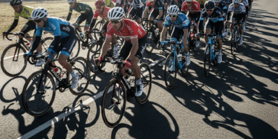 road cyclists riding in tight peloton formation on an open r 20260331 083301